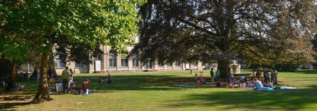 Persone sedute sotto gli alberi nel parco nella città di Baden.